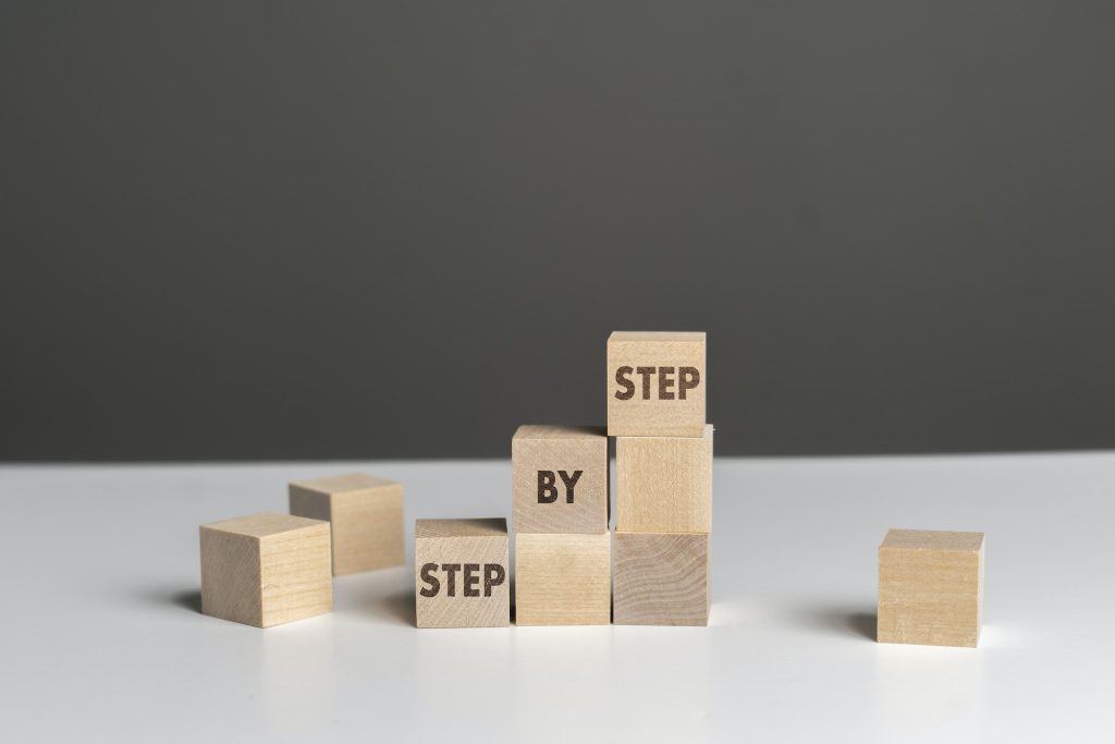 the wooden cubes blocks with "step by step" text, personal growth concept